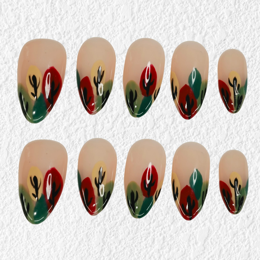 Ten almond-shaped press-on nails arranged in two rows of five on a textured white background. The nails feature a beige base with a green and red leaf pattern and small yellow and white accents.